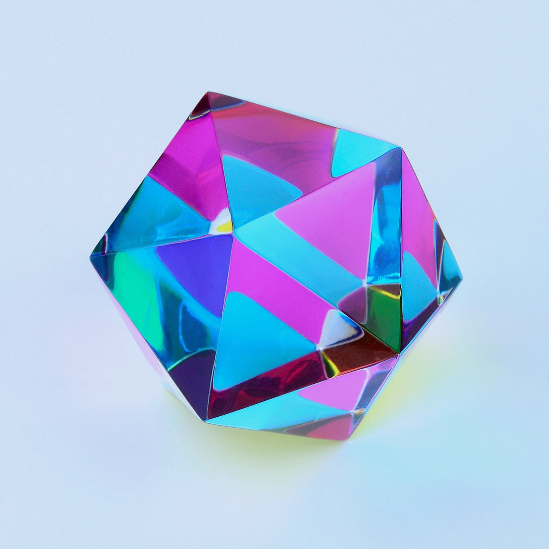 The Motus, a translucent CMY icosahedron, catching the light on a desk