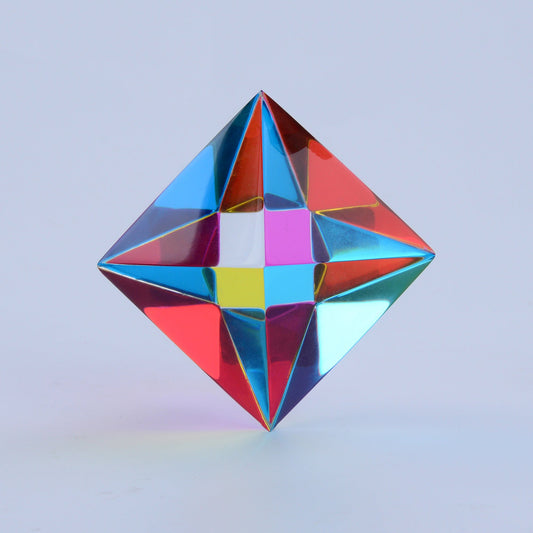 The Aether, a translucent CMY octahedron, standing on a desk in natural light