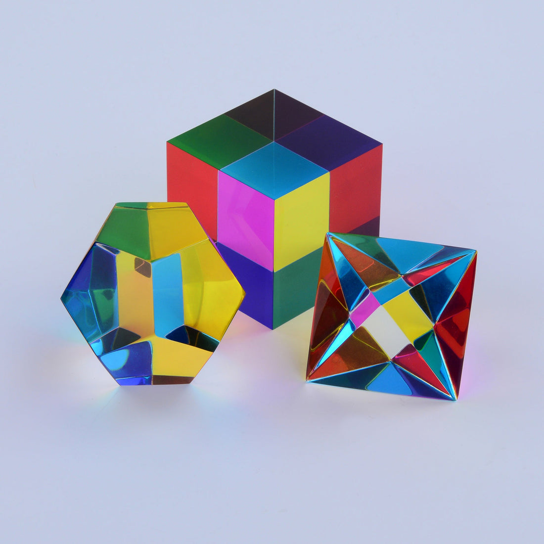 Three translucent CMY solids producing dozens of distinct colours where their faces overlap in sunlight