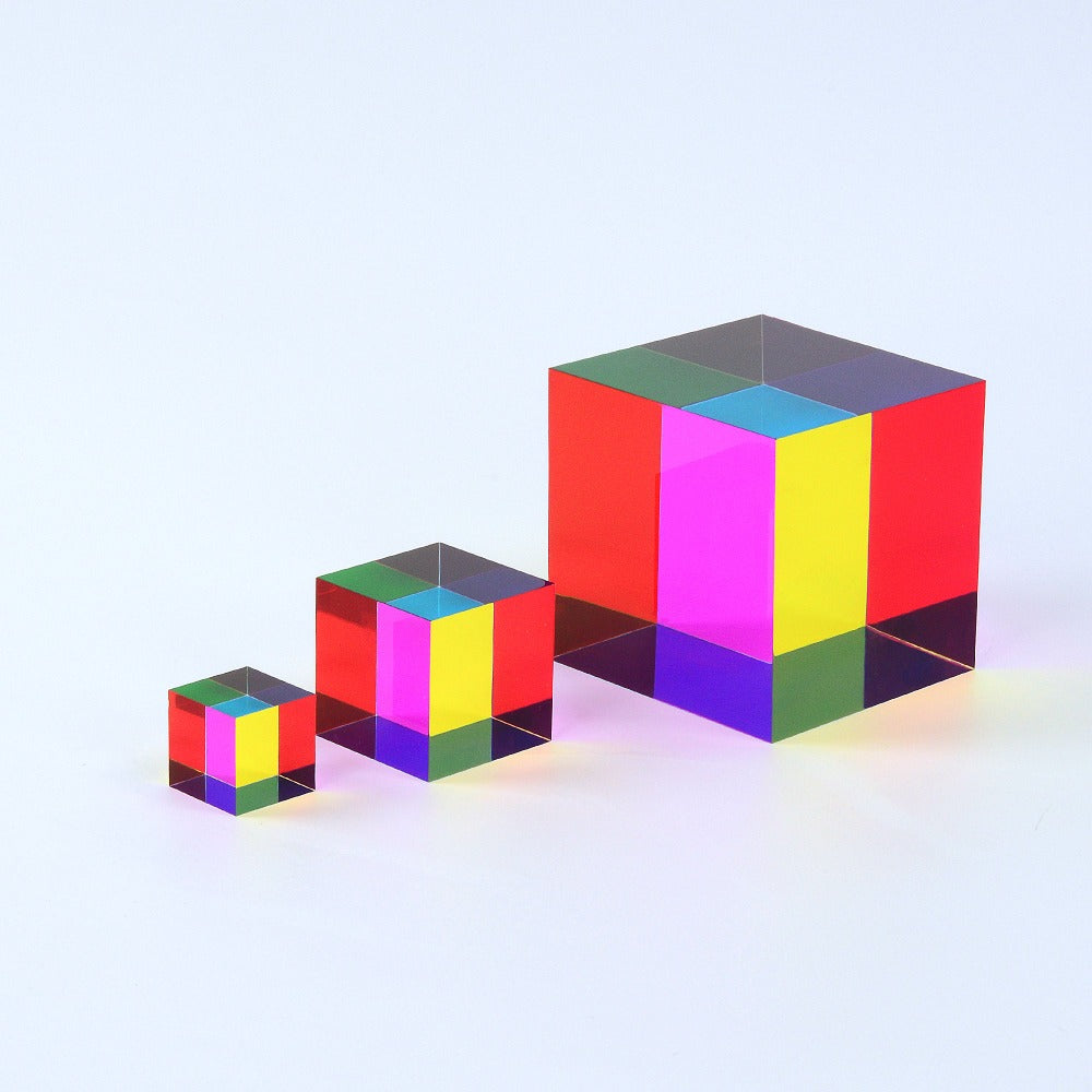 A translucent CMY Cube held up to the light, its cyan, magenta and yellow faces overlapping into new colours