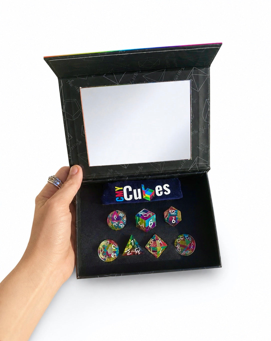 Hand holding the open Septem Aleae display box with all seven colour mixing dice inside